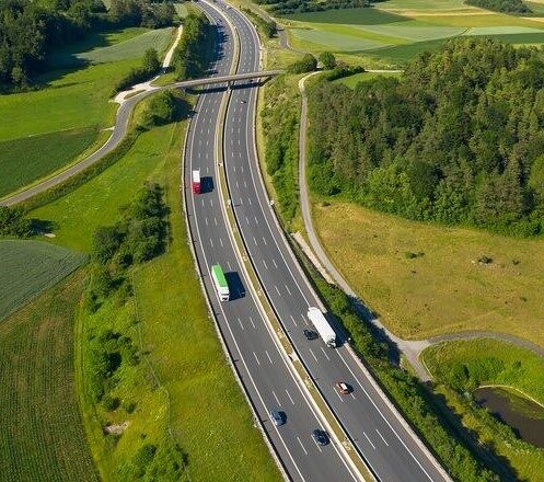 Trucks on Highway and Wind Turbines, Aerial View-GettyImages-1299327916-Med